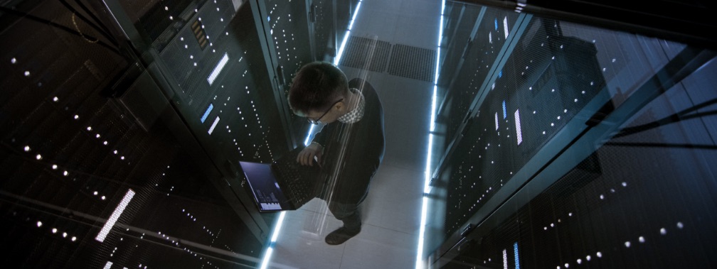 male worker on laptop in server room