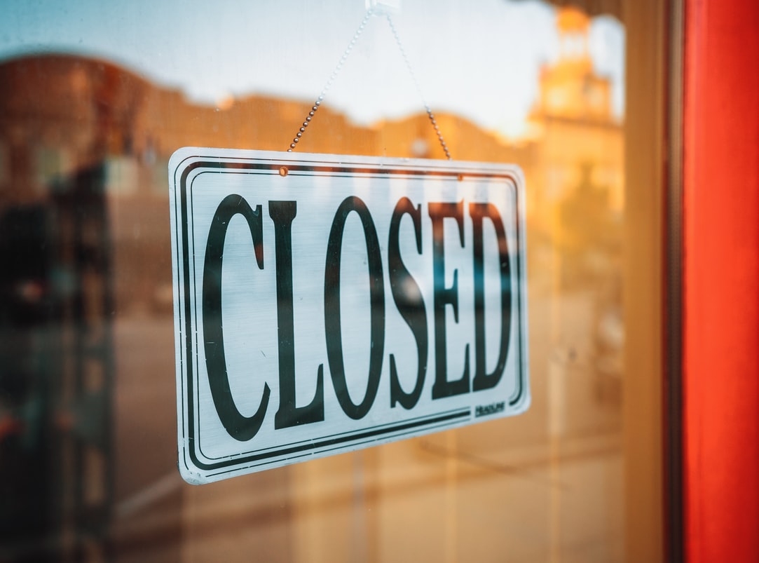 closed sign hanging on building window